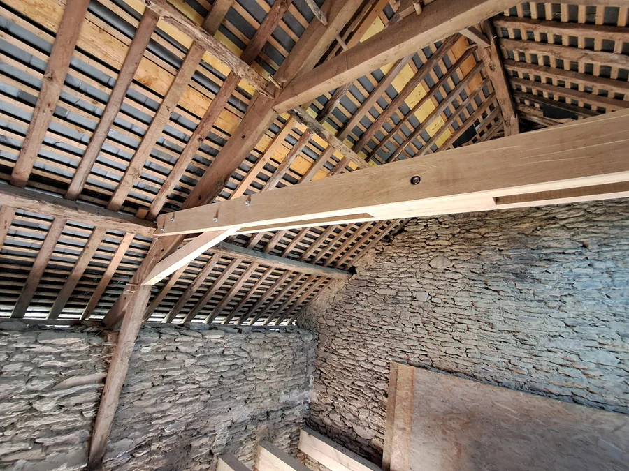 Comble d’une grange en pierre avec charpente en bois restaurée